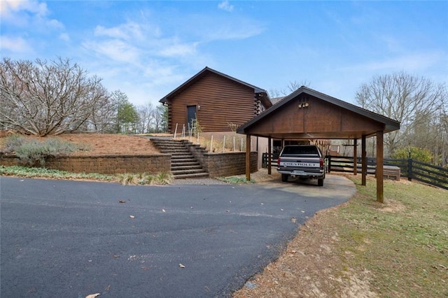 5505 Whitehall Rd, Lula, GA 30554 - view of front of house with stairway, log siding, fence, aphalt driveway, and a carport