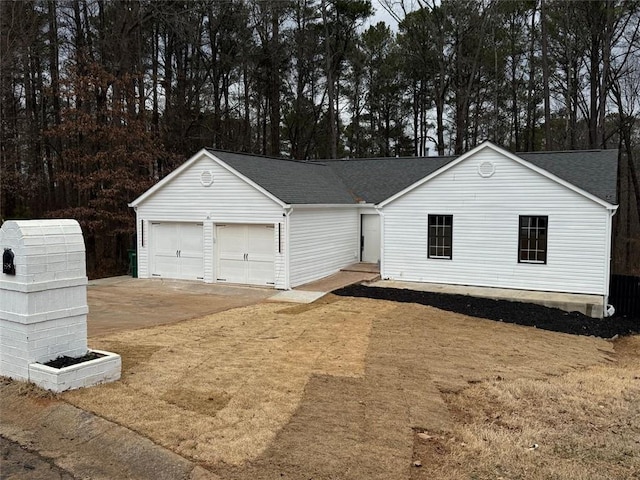 view of front of property with roof with shingles, driveway, and an attached garage