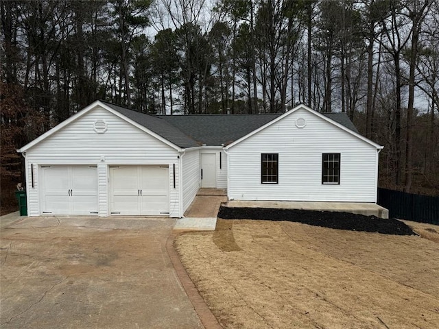 single story home featuring a garage, driveway, and roof with shingles