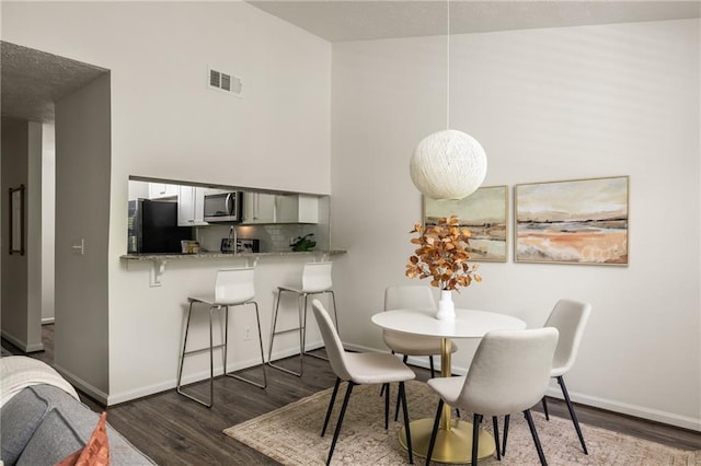 448 Teal Ct, Roswell, GA 30076 - dining space with baseboards, visible vents, dark wood finished floors, and a towering ceiling