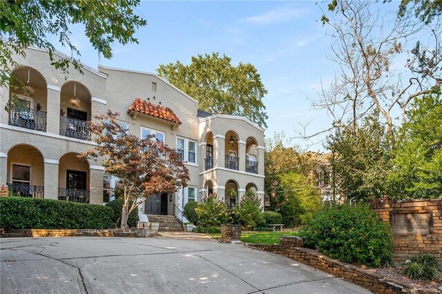 mediterranean / spanish home featuring a front yard and a balcony