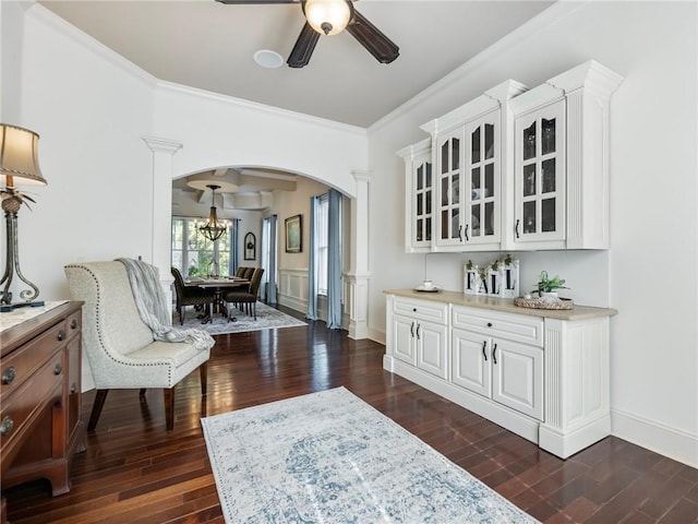 interior space featuring crown molding, dark wood-type flooring, and ceiling fan