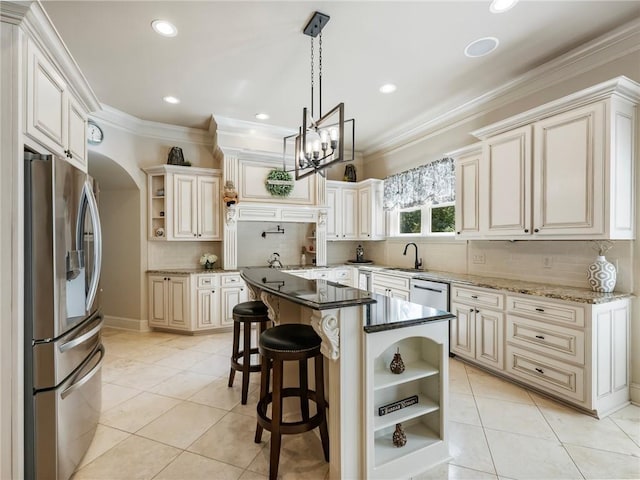 kitchen with a breakfast bar, appliances with stainless steel finishes, a kitchen island, decorative light fixtures, and dark stone counters