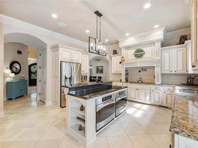 kitchen featuring dark stone countertops, white cabinetry, a center island, and appliances with stainless steel finishes