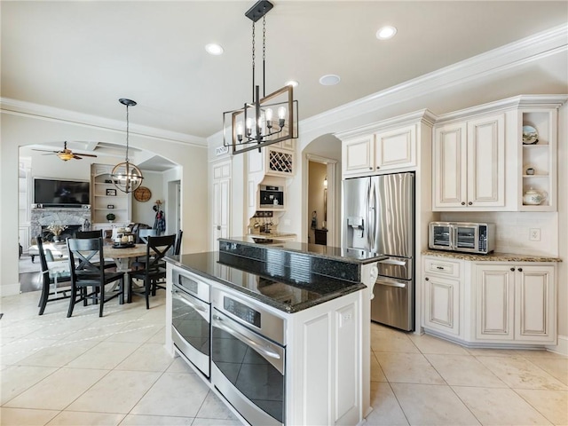 kitchen featuring stainless steel appliances, light tile patterned flooring, hanging light fixtures, and dark stone counters