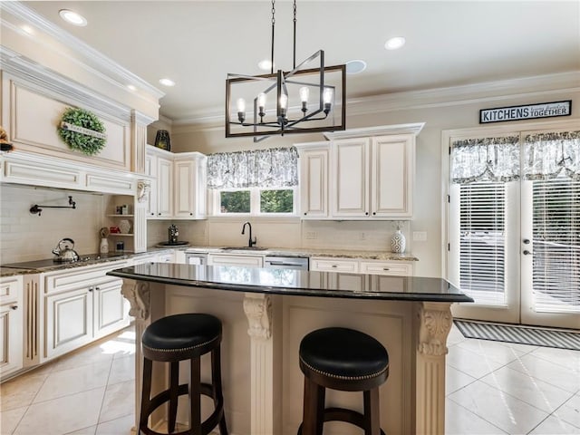 kitchen featuring a breakfast bar, black electric stovetop, a center island, and dark stone countertops