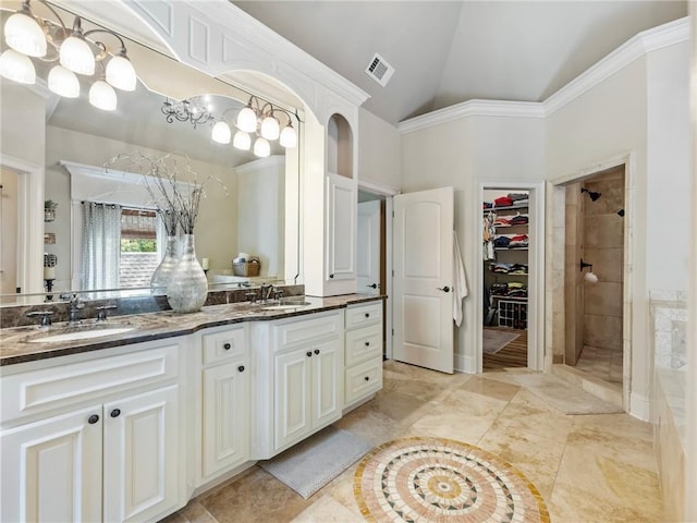 bathroom featuring crown molding, tiled shower, vanity, and vaulted ceiling