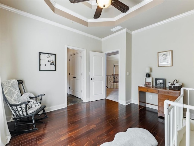 sitting room with a raised ceiling, ornamental molding, dark wood-type flooring, and ceiling fan