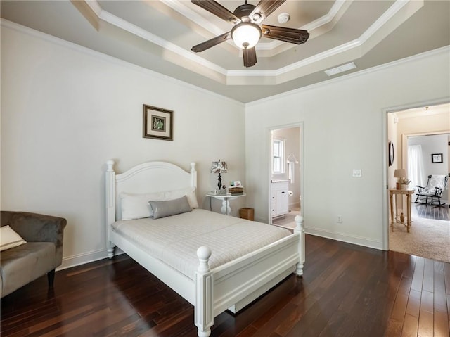 bedroom with a raised ceiling, ornamental molding, dark wood-type flooring, and ensuite bathroom