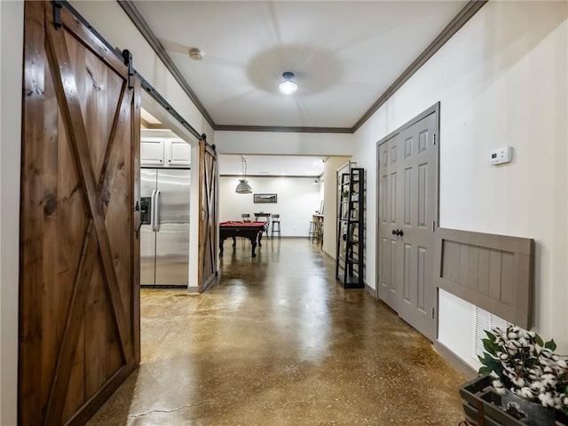 interior space with crown molding, a barn door, and concrete flooring