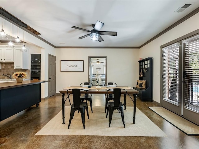 dining space with crown molding, sink, and ceiling fan