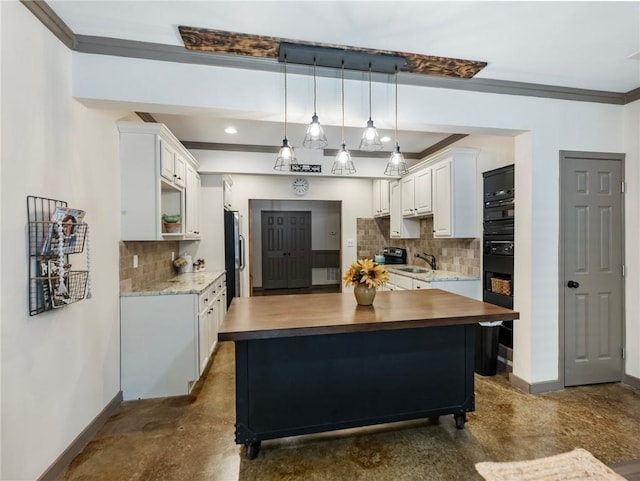 kitchen with sink, white cabinetry, tasteful backsplash, hanging light fixtures, and ornamental molding