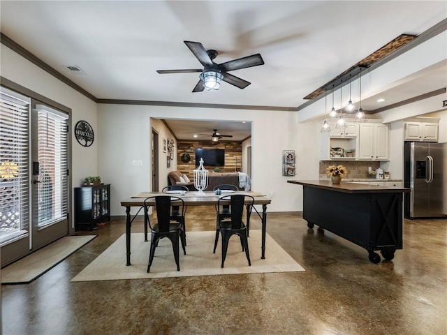 dining area featuring crown molding, ceiling fan, and a fireplace