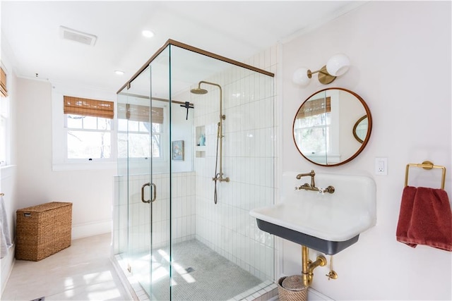 bathroom featuring a stall shower, a sink, and visible vents