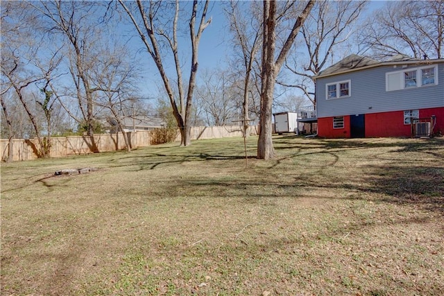 view of yard with fence and central AC unit