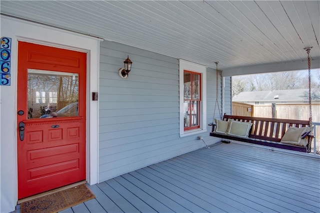 wooden deck with a porch and fence