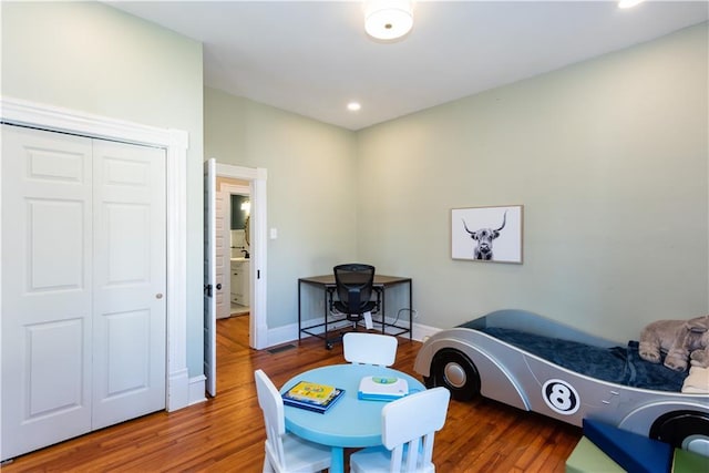 bedroom featuring a closet, wood finished floors, and baseboards