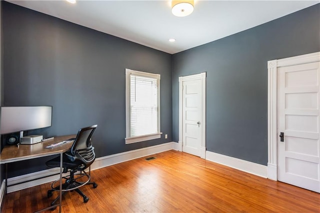 office space with visible vents, baseboards, and wood finished floors