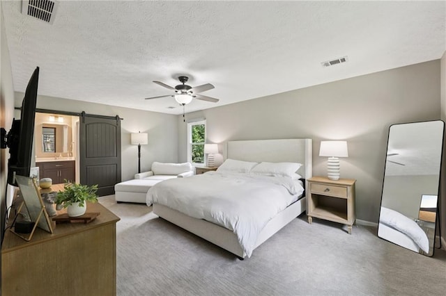 4733 Eidson Rd, Dunwoody, GA 30360 - carpeted bedroom with a barn door, ceiling fan, a textured ceiling, and ensuite bathroom
