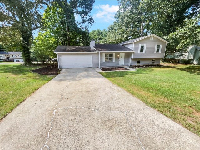 tri-level home featuring a front lawn and a garage