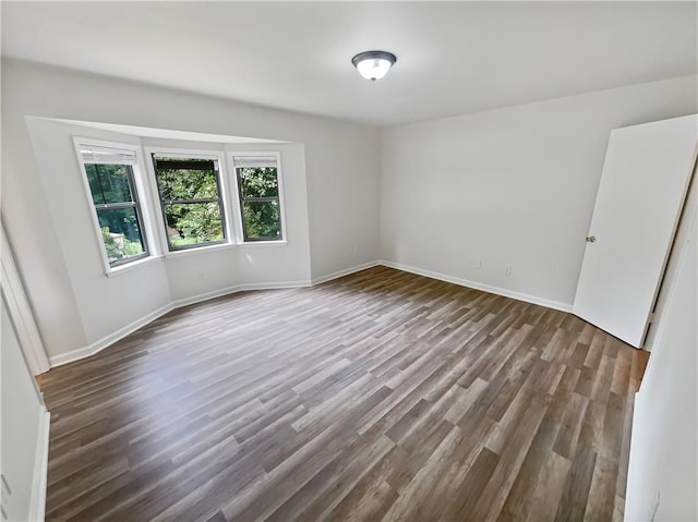 unfurnished room with dark hardwood / wood-style flooring