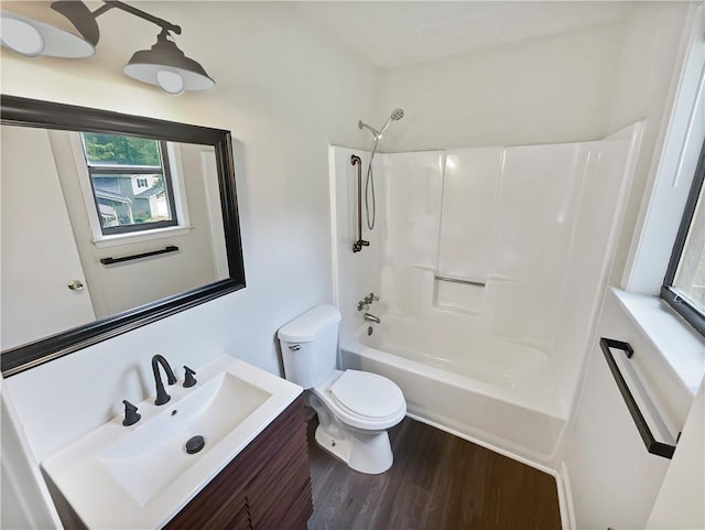 full bathroom featuring hardwood / wood-style flooring, vanity, shower / bathtub combination, and toilet