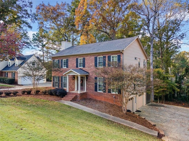 colonial home featuring a garage and a front yard