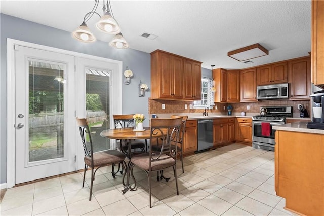 10 Callaway Ct, Hiram, GA 30141 - kitchen with appliances with stainless steel finishes, decorative backsplash, light countertops, decorative light fixtures, and a textured ceiling