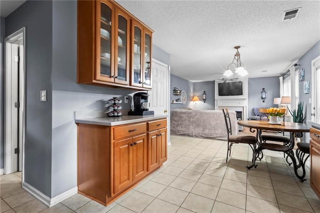 10 Callaway Ct, Hiram, GA 30141 - kitchen with brown cabinetry, light tile patterned floors, glass insert cabinets, light countertops, and a textured ceiling