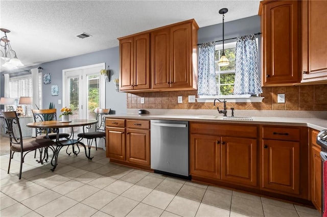 10 Callaway Ct, Hiram, GA 30141 - kitchen with stainless steel dishwasher, brown cabinets, hanging light fixtures, light countertops, and plenty of natural light