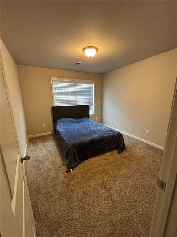 carpeted bedroom featuring baseboards and visible vents