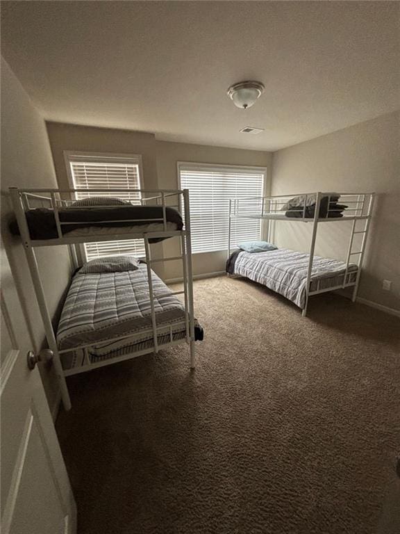 carpeted bedroom featuring visible vents and baseboards