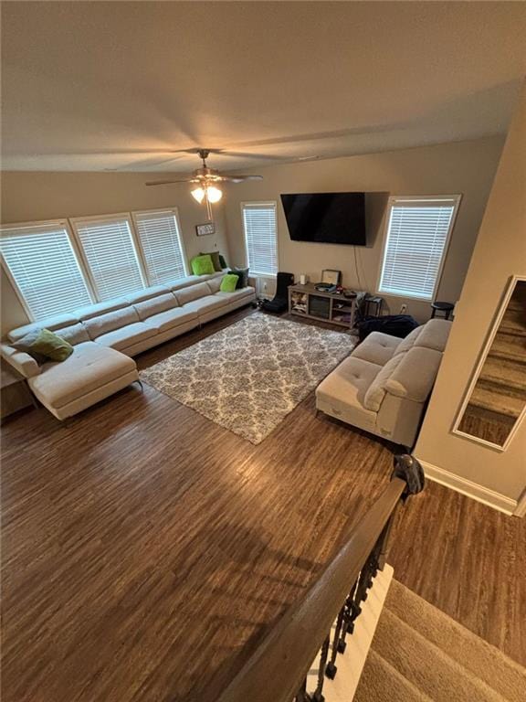 living area featuring ceiling fan, baseboards, and wood finished floors