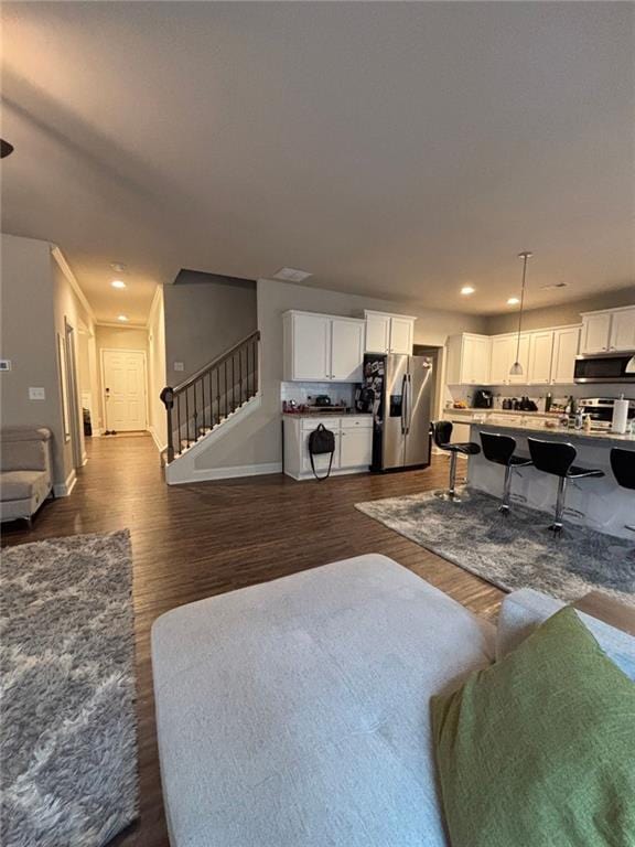 living area with baseboards, stairway, dark wood finished floors, and recessed lighting