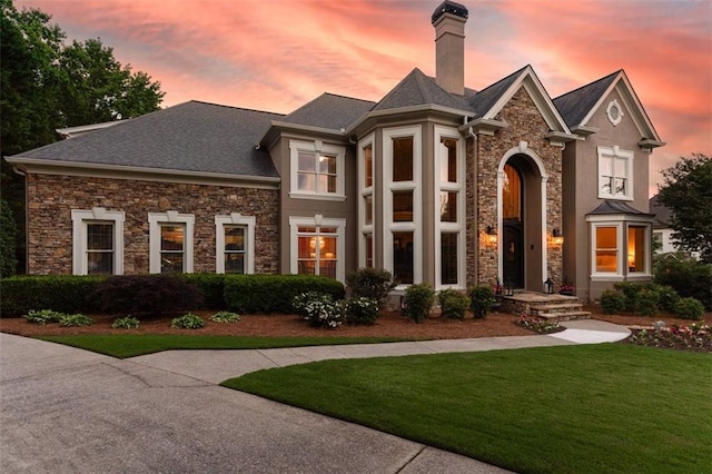 7025 Kettering Ln, Suwanee, GA 30024 - view of front facade featuring stone siding, a yard, and a chimney