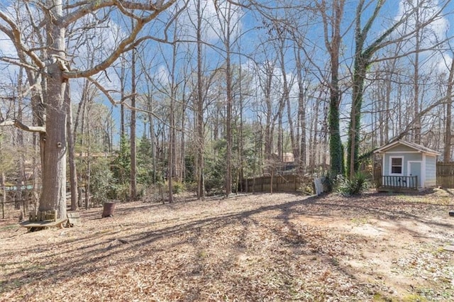 view of yard featuring an outdoor structure and fence