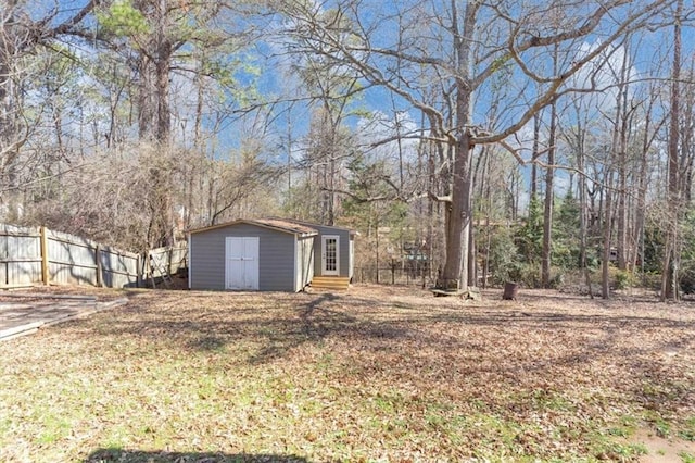 view of yard featuring entry steps, fence, and an outbuilding