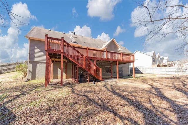 rear view of property featuring a fenced backyard, stairs, and a deck