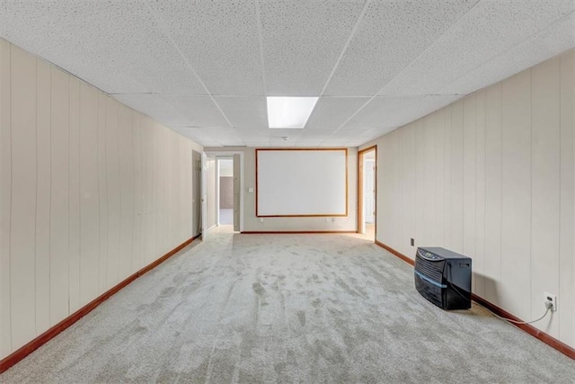 unfurnished room with carpet floors, baseboards, and a drop ceiling