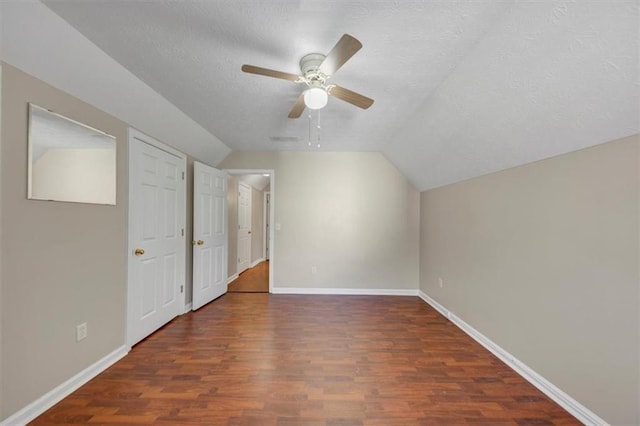 additional living space featuring a textured ceiling, ceiling fan, lofted ceiling, wood finished floors, and baseboards