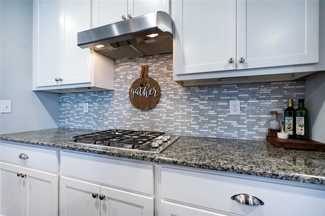 kitchen with white cabinetry, ventilation hood, stainless steel gas cooktop, decorative backsplash, and dark stone counters