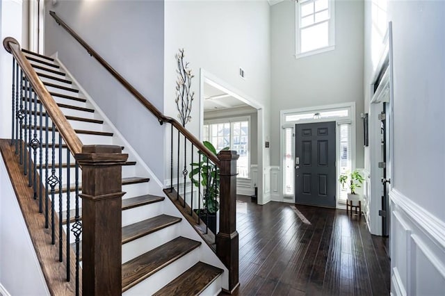 entryway featuring a towering ceiling and dark hardwood / wood-style flooring