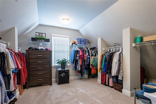 spacious closet with vaulted ceiling and light carpet