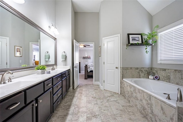 bathroom with vanity, high vaulted ceiling, tiled bath, and ceiling fan