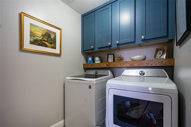 clothes washing area featuring cabinets and separate washer and dryer