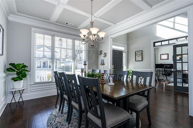 dining room featuring coffered ceiling, crown molding, a wealth of natural light, and a chandelier