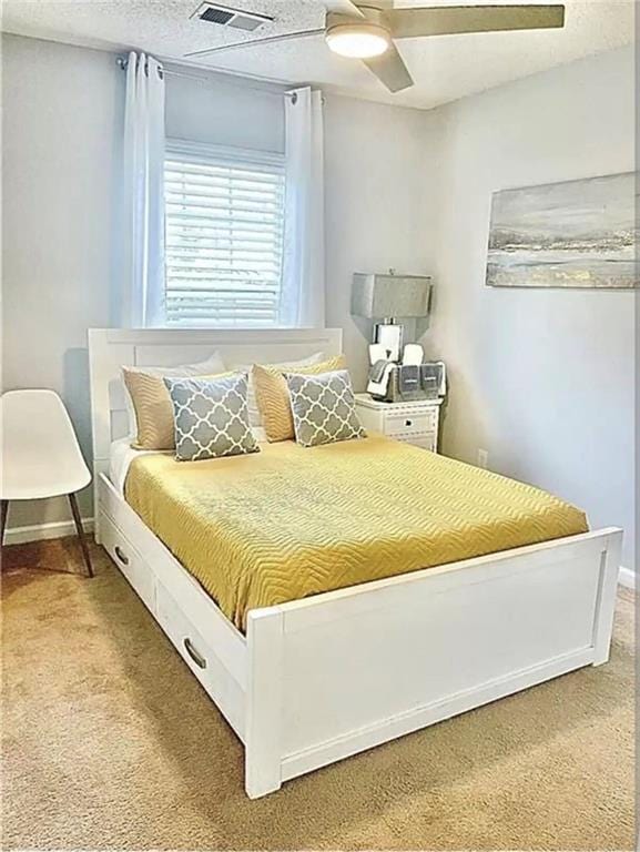 bedroom featuring light carpet, ceiling fan, visible vents, and baseboards