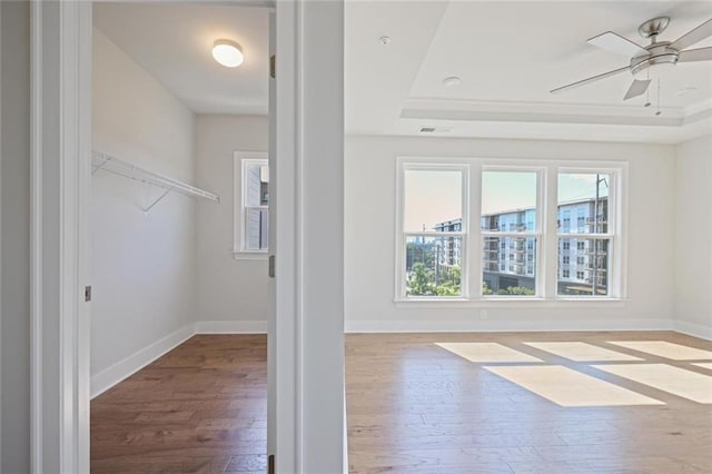 1030 Burnside Pl NW, Atlanta, GA 30318 - spacious closet featuring a tray ceiling, wood-type flooring, and ceiling fan