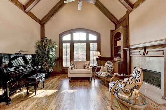 8340 Royal Melbourne Way, Duluth, GA 30097 - sitting room with high vaulted ceiling, a premium fireplace, a wainscoted wall, a ceiling fan, and wood finished floors