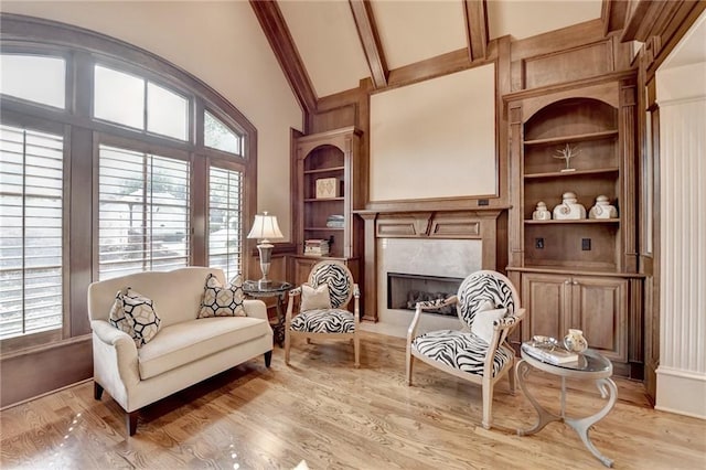 8340 Royal Melbourne Way, Duluth, GA 30097 - living area with high vaulted ceiling, light wood-style floors, built in shelves, a high end fireplace, and beam ceiling